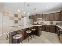Beautiful kitchen with granite counters, dark cabinets, tile floors, and an eat-in kitchen island at 9132 S Parkside Dr, Tempe, AZ 85284