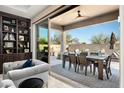 Inviting outdoor patio with dining table and chairs, sliding glass doors, and a serene view of the backyard at 9865 E Piedra Dr, Scottsdale, AZ 85255