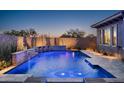 Inviting pool with a waterfall feature, underwater lighting, and a tiled patio perfect for evening relaxation at 9865 E Piedra Dr, Scottsdale, AZ 85255