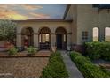 Inviting front porch with arched columns, stone accents, and comfortable seating area at 11785 N 143Rd Dr, Surprise, AZ 85379