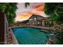 Resort-style backyard featuring a sparkling pool, covered patio, and lush landscaping at 11785 N 143Rd Dr, Surprise, AZ 85379