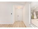 Bright entryway with light wood flooring and ample natural light from a window with blinds at 12109 N 127Th Dr, El Mirage, AZ 85335