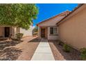 Inviting entryway with covered porch and desert landscaping leading to a secure front door at 12109 N 127Th Dr, El Mirage, AZ 85335
