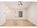 Open living space with wood flooring, ceiling fan and a large window providing natural light at 12109 N 127Th Dr, El Mirage, AZ 85335