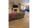 Inviting living room with a fireplace, built-in shelves, ceiling fan, and tile floors at 14968 N 134Th Ln, Surprise, AZ 85379