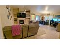 Cozy living room featuring a fireplace, ceiling fan, tile floors, and comfortable seating at 14968 N 134Th Ln, Surprise, AZ 85379