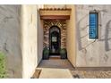 Inviting entryway showcasing an arched brick doorway with a decorative wrought iron gate and tiled roof at 1554 E Kings Ct, Gilbert, AZ 85234