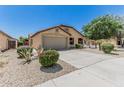 Inviting single-story home featuring a well-maintained front yard with colorful landscaping and a two-car garage at 16675 W Taylor St, Goodyear, AZ 85338