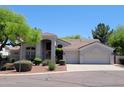 Charming single-story home with a desert landscape, three car garage and a covered front entry at 1681 S Karen Dr, Chandler, AZ 85286