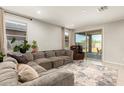 Bright living room featuring a sectional couch, and a sliding glass door leading to an outdoor patio at 17344 W Red Fox Rd, Surprise, AZ 85387