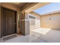 Covered front porch featuring a stylish front door and neutral color palette at 19042 E Arrowhead Trl, Queen Creek, AZ 85142