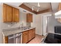 Galley kitchen featuring warm wood cabinets, stainless steel appliances, and granite countertops at 1976 N Lemon Tree Ln # 16, Chandler, AZ 85224