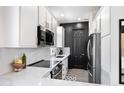 Bright kitchen featuring white cabinets, stainless steel appliances and a contrasting black brick wall at 201 S Greenfield Rd # 215, Mesa, AZ 85206