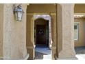 Covered entryway showcasing an ornate light fixture and a view of a dark wooden door with a floral wreath at 20243 E Poco Calle --, Queen Creek, AZ 85142