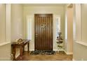 Elegant entryway with a dark wood door, white plantation shutters, and decorative accents on a tiled floor at 20243 E Poco Calle --, Queen Creek, AZ 85142