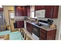 A functional kitchen featuring dark wood cabinetry and sleek, modern appliances at 3345 E University Dr # 47, Mesa, AZ 85213