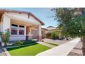 Charming home with a stone and stucco facade, manicured lawn, and inviting covered porch at 3877 E Oxford Ln, Gilbert, AZ 85295