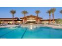 Large pool with lounge chairs at the community center with palm trees at 39514 N Kaden Ln, San Tan Valley, AZ 85140