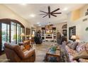 Cozy living room with a brick fireplace, a ceiling fan, and large windows with wood shutters at 401 N Cholla St, Chandler, AZ 85224