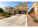Inviting two-story home featuring a dark garage door and low-water landscaping at 4580 E Gagarinite Ln, San Tan Valley, AZ 85143