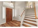 Inviting foyer with wood floors, a decorative front door, and staircase at 4746 W Taro Dr, Glendale, AZ 85308