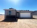 New construction home featuring a two-car garage and a gray stucco exterior under a clear blue sky at 47719 W Moeller Rd, Maricopa, AZ 85139