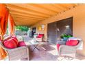 Relaxing covered patio with comfortable seating, tile flooring, and privacy curtains for outdoor enjoyment at 4804 S Elm St, Tempe, AZ 85282