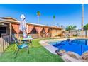 Outdoor pool area with a covered patio, artificial turf, and desert landscaping perfect for relaxing at 4804 S Elm St, Tempe, AZ 85282