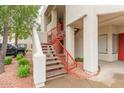 Exterior view showcasing the condo's red metal staircase and colorful landscaping at 750 E Northern E Ave # 2145, Phoenix, AZ 85020