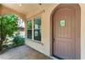 Covered entryway featuring a brown door with window insert and desert landscaping at 9302 E Horseshoe Bend Dr, Scottsdale, AZ 85255