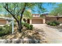Tan two story home featuring a two car garage and desert landscaping at 9302 E Horseshoe Bend Dr, Scottsdale, AZ 85255