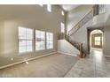 Open living room featuring large windows, high ceilings and a wooden staircase at 9302 E Horseshoe Bend Dr, Scottsdale, AZ 85255