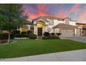 Beautifully landscaped two-story home featuring a lush green lawn and a three-car garage at 1001 N Peppertree Dr, Gilbert, AZ 85234