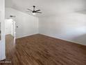 Open-concept living room showcasing wood-look flooring, neutral walls, and a modern ceiling fan at 1019 N 62Nd Ave, Phoenix, AZ 85043