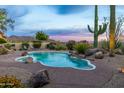 Desert oasis featuring a beautiful freeform pool, lush landscaping, and captivating mountain views at 10875 E Mirasol Cir, Scottsdale, AZ 85255