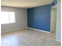 Living room boasts tile flooring, grey walls, and a large window for natural light at 1130 E Butler Dr # B4, Phoenix, AZ 85020