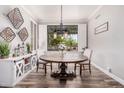 Inviting dining room featuring a rustic wooden table and ample natural light from the large window at 1421 W Saltsage Dr, Phoenix, AZ 85045