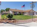 Well-maintained front yard with lush green grass, colorful flower beds, and mature landscaping at 2003 W Tyson St, Chandler, AZ 85224