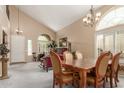 Elegant dining room with high ceilings, large windows, a chandelier, and ornate wood furniture at 22022 W Moonlight Path, Buckeye, AZ 85326