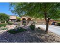 Charming home featuring a well-manicured front yard, desert landscaping, and a decorative windmill at 22022 W Moonlight Path, Buckeye, AZ 85326