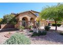 Lovely two-story home with a front yard featuring desert landscaping and mature trees at 22022 W Moonlight Path, Buckeye, AZ 85326