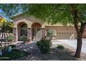 Inviting home with arched entryway, desert landscaping, and a two-car garage at 22022 W Moonlight Path, Buckeye, AZ 85326