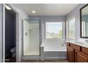 Bright bathroom with a separate shower, soaking tub, and double sink vanity, offering relaxation and convenience at 36114 W Vera Cruz Dr, Maricopa, AZ 85138