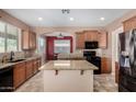 Well-lit kitchen featuring granite countertops, stainless steel appliances, and an island, great for cooking at 36114 W Vera Cruz Dr, Maricopa, AZ 85138
