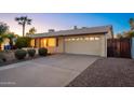 View of single-story home featuring a two-car garage and a spacious concrete driveway at 3624 E Hearn Rd, Phoenix, AZ 85032