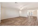Open living room features wood-look flooring, light walls and entry to patio at 3624 E Hearn Rd, Phoenix, AZ 85032