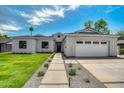 Beautiful home featuring a manicured lawn, stylish stone walkway and attached two car garage at 4107 E Edgemont Ave, Phoenix, AZ 85008