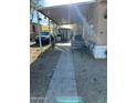 View of the front entrance with covered patio, parking, and small storage shed at 4211 W Roosevelt St # 235, Phoenix, AZ 85009
