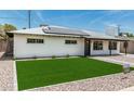 Inviting single-story home with a well-maintained lawn and modern solar panels on the roof at 4531 N 12Th Dr, Phoenix, AZ 85013