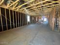 Spacious unfinished living room showcasing bare studs and concrete flooring, ready for customization at 47720 W Kenner Dr, Maricopa, AZ 85139